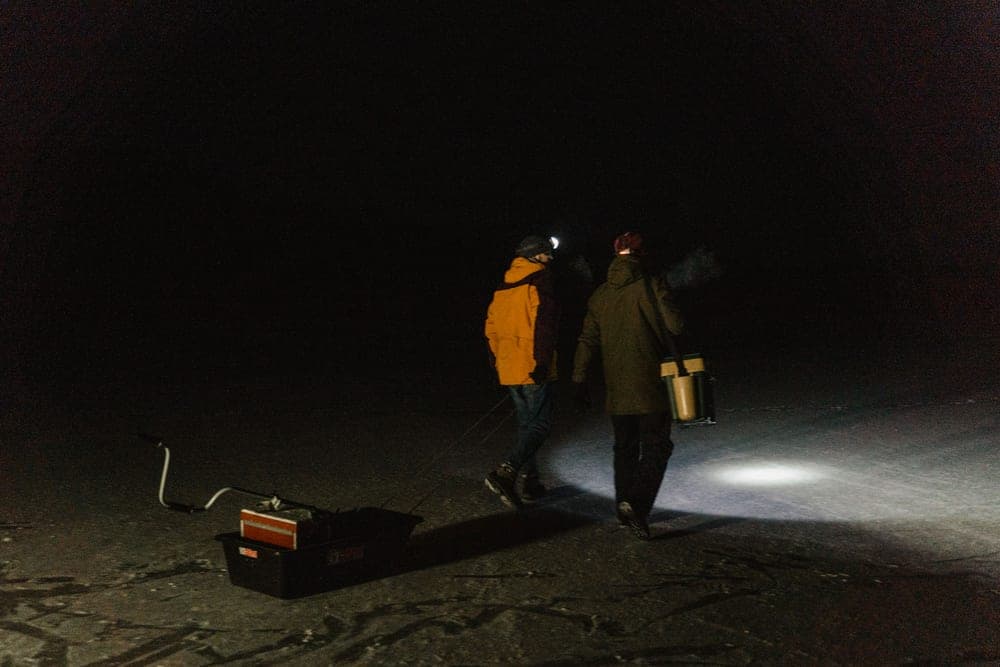 Two people walking at night wearing headlamps