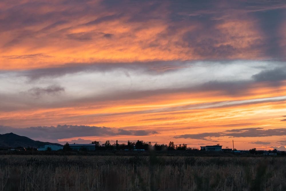 A bright sunset sky over quiet rural land