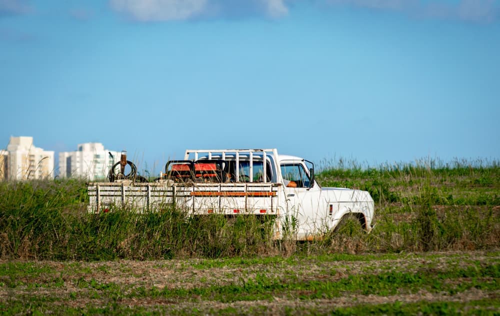 A white pickup truck parked in a wide rural field